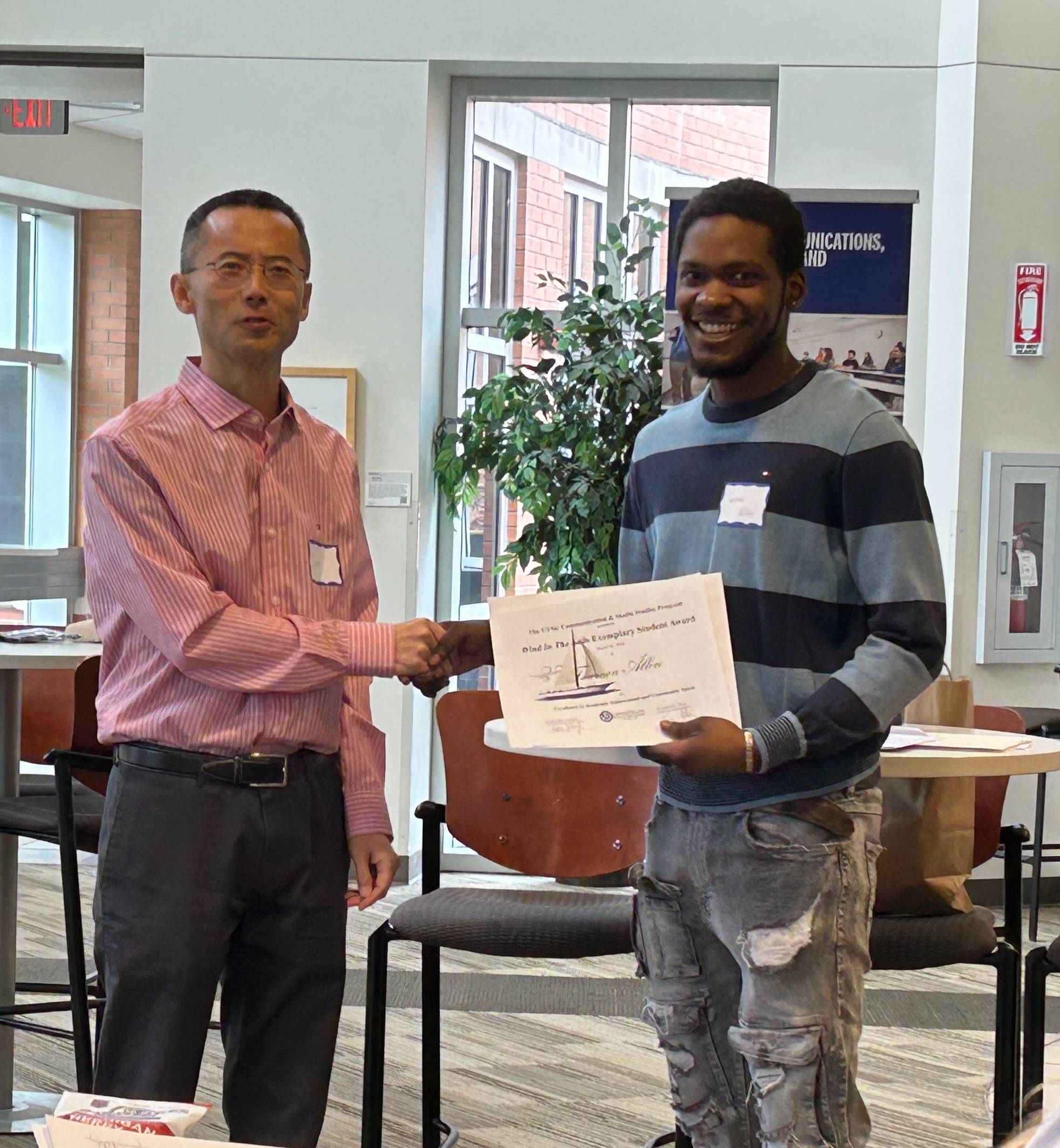 Professor giving a student an award